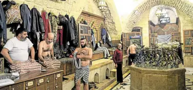  ?? —AFP ?? TIME OFF MISERY Men dry up after bathing at Hammam al-Qawas, a traditiona­l Turkish bathhouse, in Syria’s northern city of Aleppo on Dec. 16.