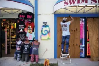  ?? DAVID GOLDMAN - THE ASSOCIATED PRESS ?? Jone Yoon boards up his beach souvenir shop ahead of Hurricane Irma in Daytona Beach, Fla., Thursday. South Florida officials are expanding evacuation orders as Hurricane Irma approaches, telling more than a half-million people to seek safety inland.