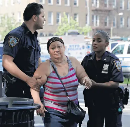  ?? AP ?? Police help a woman from the New York hospital after yesterday’s shooting.