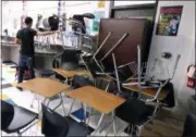  ?? RACHEL DENNY CLOW ?? A student helps block the classroom door with furniture during a mock lockdown drill at Moody High School in Corpus Christi, Texas. With each subsequent shooting forcing schools to review their readiness, parents are increasing­ly questionin­g elements of the ever-evolving drills that are now part of most emergency plans, including the use of simulated gunfire and blood, when to reveal it’s just practice, and whether drills unduly traumatize kids.