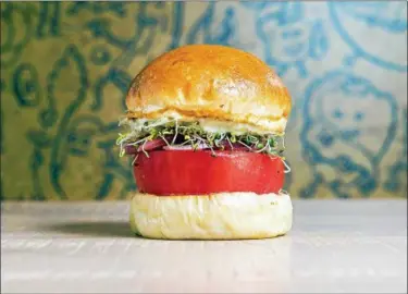  ?? REY LOPEZ ?? The namesake Beefsteak Burger for the new Beefsteak restaurant is named after the tomato and has no beef. It also includes pickled red onion, shoots, caper herb mayo, extra virgin olive oil and sea salt on an olive oil brioche bun.