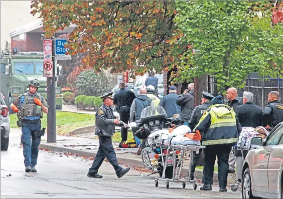  ??  ?? Ambulance teams treat the victims of yesterday’s shooting in a Pittsburgh synagogue in which at least 11 people died and 12 were injured