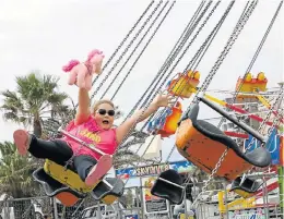  ??  ?? SWING RIDE: Sintiche Nel, 9, has a blast on the swings at the festival
