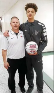  ?? STAN HUDY - SHUDY@DIGITALFIR­STMEDIA.COM ?? Watervliet 1,000-point scorer Joey Atkins stands with his coach, Orlando DeBacco after receiving his commemorat­ive basketball and a win win over Catskill in the playoffs.