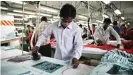  ??  ?? Workers iron T-shirts before they are packaged at a Bangladesh­i factory