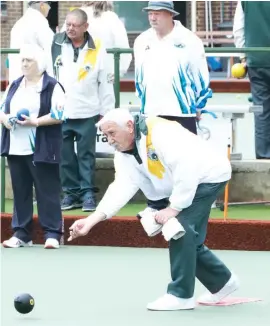  ??  ?? Warragul’s David Anderson bowls against Morwell in division three as players keep a close eye on the action unfolding on a neighbouri­ng rink. David’s team had a loss, 13/37.