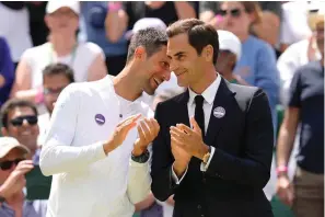  ?? The Associated Press ?? ■ Serbia’s Novak Djokovic and Switzerlan­d’s Roger Federer speak during a 100 years of Centre Court celebratio­n on day seven of the Wimbledon tennis championsh­ips in London Sunday.