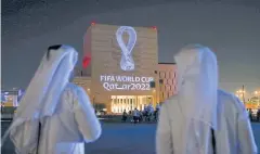  ?? AFP ?? People watch the Qatar 2022 logo in Doha last year.