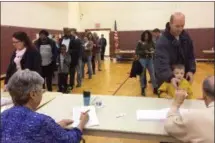  ?? EVAN BRANDT — DIGITAL FIRST MEDIA ?? Upper Pottsgrove voters line up at the registrati­on table at Pottsgrove Middle School Tuesday.