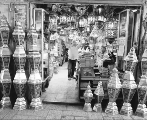  ??  ?? Issam Zughaiar, 67, a Palestinia­n vendor arranges lamp shades at his shop in a market in Jerusalem’s Old City. — Reuters photo