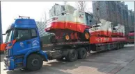  ??  ?? Trucks ship Lovol-branded combine harvesters to a port for export to Sudan.