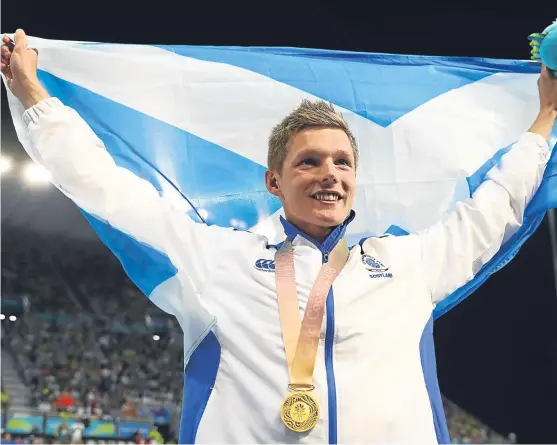  ?? Picture: Getty Images. ?? Swimmer Duncan Scott celebrates with his gold medal after winning the 100m freestyle event on his way to becoming the first Scottish athlete to win five medals at a Commonweal­th Games. The former Strathalla­n School pupil still has two more medal...