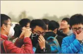  ?? WANG JING / CHINA DAILY ?? Tourists don masks at Tian’anmen Square on a dusty day in Beijing on Wednesday.