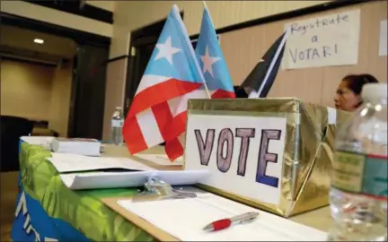  ?? JULIO CORTEZ — THE ASSOCIATED PRESS ?? On April 14, a voter registrati­on booth is staffed during an event to help Puerto Rico hurricane victims in Elizabeth, New Jersey. The intensity of political attention ahead of midterm election is new for Puerto Ricans, who are accustomed to not having...