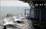  ?? BULLIT MARQUEZ/AP ?? U.S. Navy officers operate in the flight deck control tower as military aircraft sit on the flight deck of the carrier USS Carl Vinson as it anchors off Manila on Saturday.