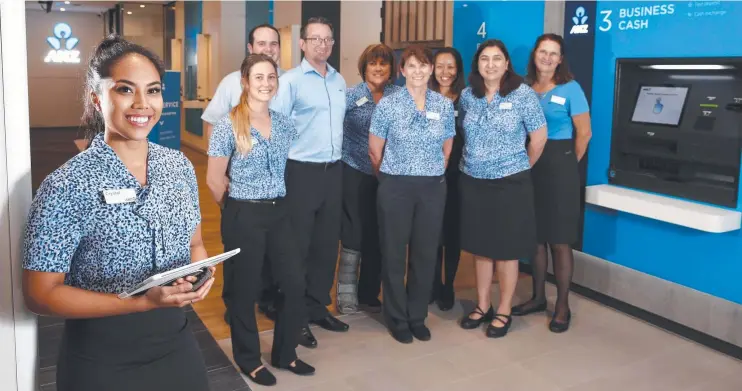  ?? Picture: ANNA ROGERS ?? DIGITAL READY: ANZ Cairns Central banking consultant Crystal Diaz and branch manager Christophe­r Coco with the staff at the newly refurbishe­d branch.
