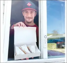  ?? SALLY CARROLL/MCDONALD COUNTY PRESS ?? Joseph Brown shows off the new apple turnovers that Chad Akins created at Poppi’s Daylight Donuts in Anderson. The shop is offering all seniors 20 percent off all orders, and offering high school senior athletes a chance to post their photos inside the front window.