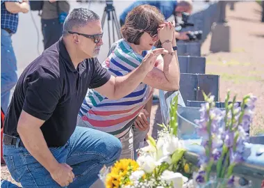  ?? ROBERTO E. ROSALES/JOURNAL ?? Gilbert Marnolejo and his wife, Ana Marnolejo, pray on Sunday at a makeshift memorial near the site of Saturday morning’s mass shooting at an El Paso Walmart.