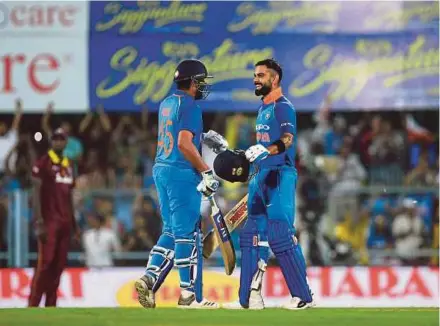  ?? AFP PIC ?? India’s Virat Kohli (right) celebrates with Rohit Sharma after completing his century in the first ODI against the West Indies on Sunday.