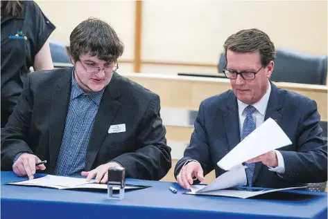  ?? BRANDON HARDER ?? RM of Sherwood Reeve Jeff Poissant and Mayor Michael Fougere sign a boundary agreement between Regina and the RM of Sherwood at city hall in Regina. The deal involves a seven-hectare parcel of land that was bought by a developer, who plans to build...