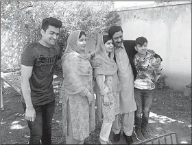  ?? AP/ABDULLAH SHERIN ?? Pakistan’s Nobel Peace Prize winner Malala Yousafzai (center) poses for a photograph with relatives Saturday during a visit to her native home Mingora in Pakistan’s Swat Valley.