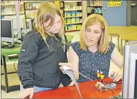  ?? TERESA WRIGHT/ THE GUARDIAN ?? Teacher Michelle Dodds helps eight-year-old Abby Jack with some robotics programmin­g at Westwood Primary school in Cornwall. Government announced 27 additional teachers will be hired this fall.