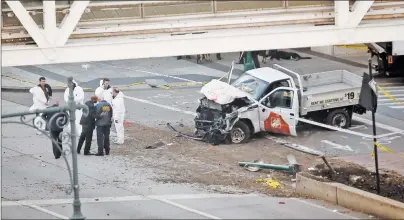  ?? AP PHOTO ?? Authoritie­s stand near a damaged Home Depot truck after a motorist drove onto a bike path near the World Trade Center memorial, striking and killing several people Tuesday.