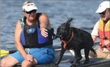  ??  ?? Kona gives owner Kathy Hick a shower as they compete against themselves for official designatio­n as Portuguese Water Dogs.