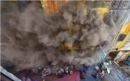  ?? — PTI ?? Smoke billows out of a shoe factory after the fire broke out in New Delhi on Tuesday.