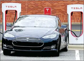  ?? AP/CHUCK BURTON ?? A Tesla car recharges at Cochran Commons shopping center in Charlotte, N.C., in June. Tesla CEO Elon Musk said Monday that the company expects to reach production of 20,000 Model 3 cars per month in December. That figure is less than previous estimates.