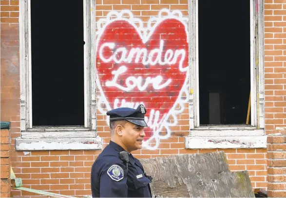  ?? TIMOTHY A. CLARY/AFP/GETTY IMAGES NORTH AMERICA/TNS ?? Camden County Police Department Officer Louis Sanchez patrols on foot in Camden, New Jersey, on May 24, 2017. In 2013, the city of Camden dissolved its police force, replacing it with a new county-run department that is helping to turn around a city that had one of the highest crime rates in the country. Police reform and falling crime statistics may have made Camden a poster child for better policing.