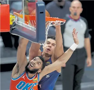  ?? Matthew Stockman, Getty Images ?? Denver forward Michael Porter Jr. dunks on Oklahoma City’s Kenrich Williams during the first quarter at Ball Arena on Friday.