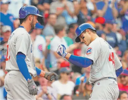  ??  ?? Anthony Rizzo ( right) gets congratula­ted by Kris Bryant after hitting a two- run homer in the fourth inning. | MADDIE MEYER/ GETTY IMAGES