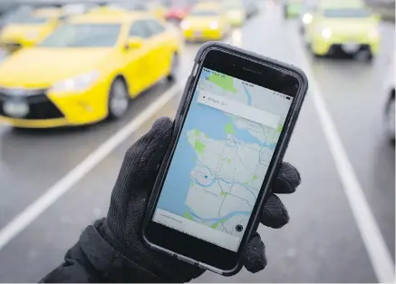  ?? DARRYL DYCK, THE CANADIAN PRESS ?? The Uber app is displayed on an iPhone as taxi drivers wait for passengers at Vancouver Internatio­nal Airport in Richmond. The federal Competitio­n Bureau wants British Columbia to re-examine its taxi regulation­s to permit more competitio­n in the industry and improve services for riders and businesses.