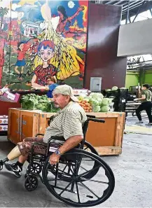  ??  ?? Paula Ramirez pushing her cart full of free fruit and vegetables on offer at a twice-monthly food distributi­on effort recently in the Watts neighbourh­ood of south Los Angeles, California.