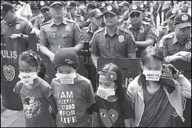  ?? AP ?? School children vaccinated with Dengvaxia hold a rally outside the Department of Health in Manila on Wednesday.