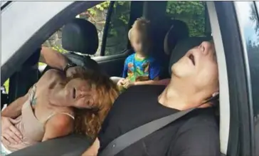  ??  ?? A young child sits in a vehicle behind his grandmothe­r and her boyfriend, both of whom are unconsciou­s from a drug overdose, in East Liverpool, Ohio, on September 7.