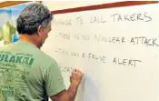  ??  ?? A Hawaii Civil Defence worker writes bullet points on a board for all staff to respond to anxious callers who were wrongly told that a nuclear missile was heading towards Hawaii