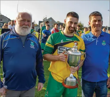  ??  ?? Wicklow League’s Liam Kilbride and John Shea present Rathnew captain Eddie Doyle with the Wicklow Cup after their victory over St Peter’s in Arklow Credit Union Park last Sunday afternoon.