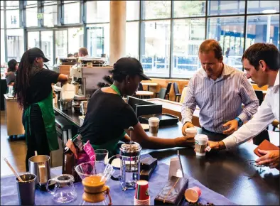  ?? News WPNS/Waldo Swiegers) ?? A barista serves customers at the pick-up counter inside a Starbucks Corp. cafe in the Sandton area of Johannesbu­rg, South Africa. (Bloomberg