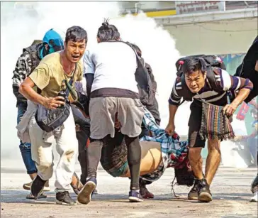  ?? STR/AFP ?? Protesters carry a wounded man shot with live rounds by security forces during a crackdown on demonstrat­ions against the military coup in Yangon on Wednesday.