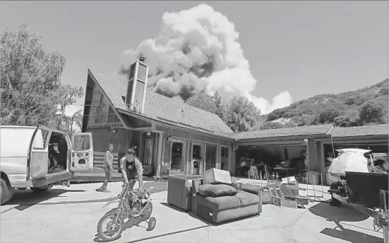  ?? Luis Sinco Los Angeles Times ?? LYTLE CREEK residents Nico and Dalia Santucci prepare to evacuate as the Blue Cut fire burns near their home Wednesday. The blaze started Tuesday morning.