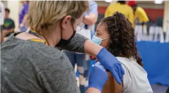  ?? AmaNDa SaBga / BOStON HeraLD ?? WAITING FOR A CHANGE: Registered Nurse Katrina Rosenberg administer­s the first dose of Pfizer's vaccine to Ashley Moran, 12, of Everett.