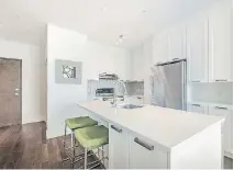  ??  ?? A mosaic backsplash, electric blue stove and pale green counter stools add a bit of colour to the mostly white kitchen area.