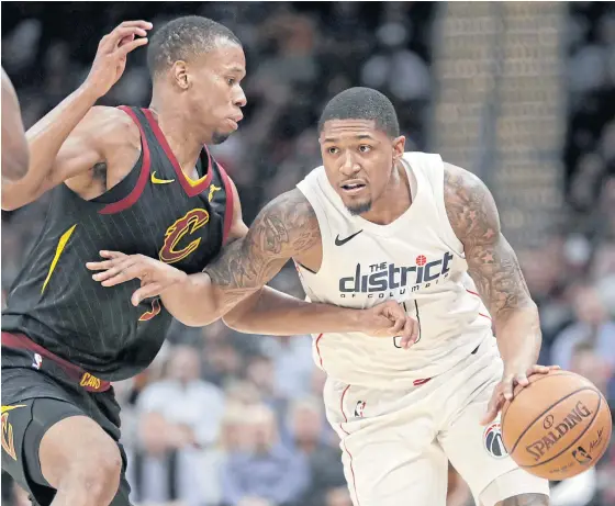  ??  ?? The Wizards’ Bradley Beal, right, drives against the Cavaliers’ Rodney Hood.