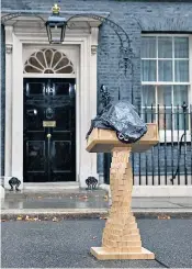  ?? ?? A bin bag protects the lectern from rain in Downing Street for Ms Truss’s speech