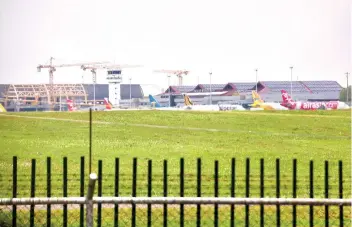  ?? SUNSTAR FOTO / ALLAN CUIZON ?? NEW TERMINAL. Shown in photo is the ongoing constructi­on of the new airport terminal (left) conducted by the GMRMegawid­e Cebu Airport Corp.