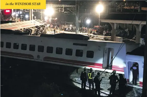  ?? JOHNSON LAI / THE ASSOCIATED PRESS ?? Rescue workers gather at the site of a fatal train derailment in Lian county in northern Taiwan on Sunday. There was no immediate word on the cause of the accident.