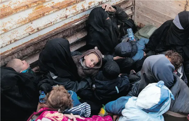  ?? FADEL SENNA / AFP ?? Two French women who fled ISIL’s last tiny pocket in Syria sit in the back of a truck near Baghuz, eastern Syria. Since December, some 25,000 people have escaped the fighting in ISIL territory in Deir Ezzor province, nearly triple what aid agencies had been prepared for.