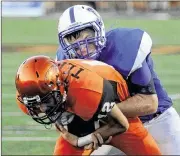  ?? MARC PENDLETON / STAFF ?? Beavercree­k quarterbac­k Jacob Maloney (front) is ridden down by Xenia’s Ken Klontz. Maloney had a pair of 1-yard touchdown runs.